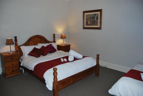 um quarto com uma cama com duas mesas de cabeceira e dois candeeiros em Jacaranda Cottage em Murray Bridge