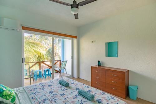 a bedroom with a bed and a dresser and a balcony at Casa Menta in Puerto Escondido