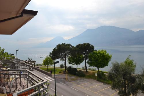 un balcone con vista sull'acqua e sulle montagne. di Hotel Smeraldo a Brenzone sul Garda