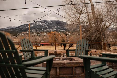 two green chairs sitting on a patio with mountains in the background at Loyal Duke Lodge in Salida
