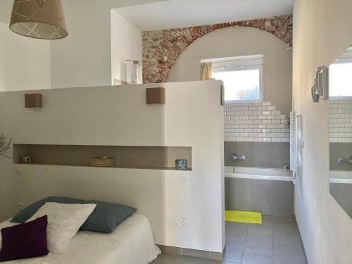 ein Schlafzimmer mit einem Bett und ein Badezimmer mit einer Badewanne in der Unterkunft Quetzal in Perpignan