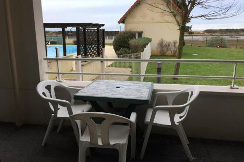d'une table et de chaises sur un balcon avec vue sur la piscine. dans l'établissement Appartement rez-de- chaussée sur le port wi-fi 4G, à Dives-sur-Mer