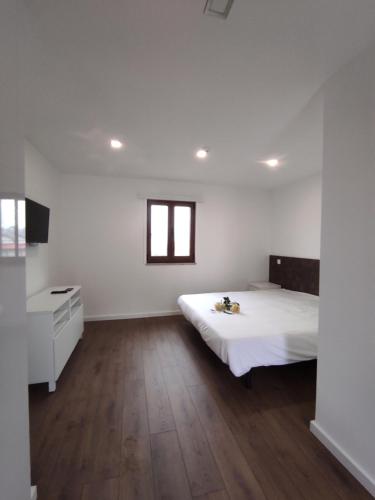 a white room with a bed and wooden floors at Quinta do Gestal - Soutelo - Retiro Rural no Minho Natureza & Sossego perto de Braga in Vila Verde
