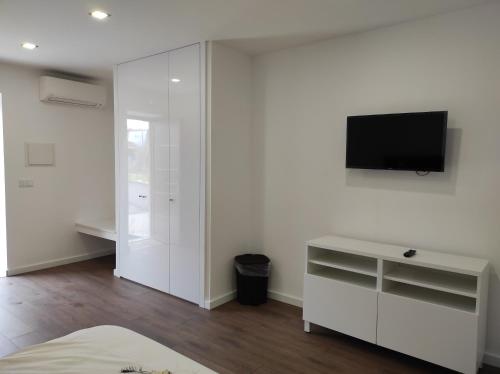 a white room with a tv on a wall at Quinta do Gestal - Soutelo - Retiro Rural no Minho Natureza & Sossego perto de Braga in Vila Verde