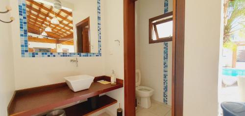 a bathroom with a sink and a toilet at Espetacular, 6 suítes, Varanda Gourmet, Bilhar, Pebolim, Praia dos Sonhos in Itanhaém