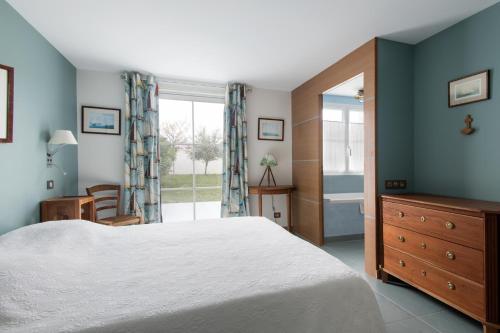 een slaapkamer met een groot bed en een raam bij Maison Thalaos in La Flotte