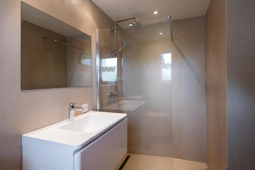 een badkamer met een witte wastafel en een douche bij Maison Thalaos in La Flotte