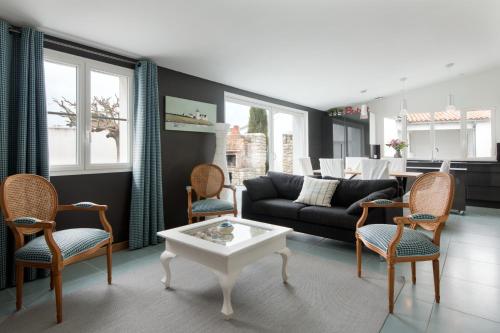 un salon avec un canapé, des chaises et une table dans l'établissement Maison Thalaos, à La Flotte