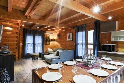 - un salon avec une table et des verres à vin dans l'établissement Chalet chaleureux à Orlu avec Jacuzzi et vue sur la montagne, à Orlu