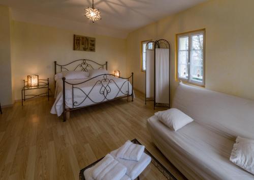 a bedroom with a bed and a couch in it at La Clé des Champs des Abers in Saint-Pabu