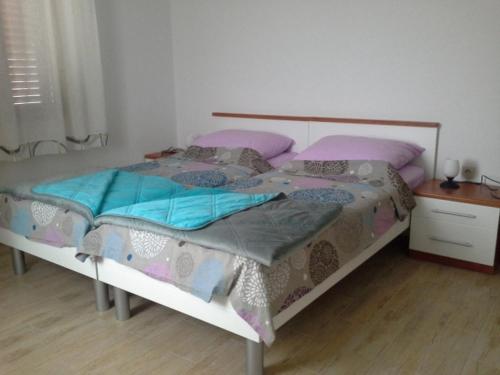 a bedroom with a large bed with pink and blue pillows at Apartment in Susak with air conditioning, W-LAN (3865-1) in Susak