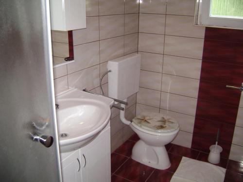 a bathroom with a toilet and a sink at Guesthouse Lopar (568) in Lopar