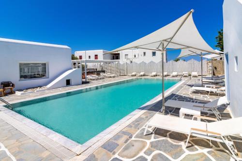 a swimming pool with lounge chairs and a house at Aeolos Resort in Mýkonos City