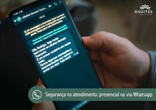a person holding a cell phone in their hand at eSuites Savassi Toscanini in Belo Horizonte