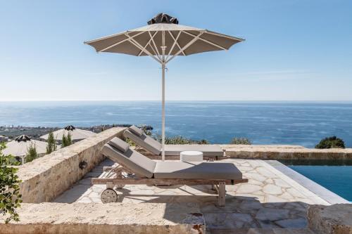 a chair and an umbrella next to a pool at Amani Living in Stoupa