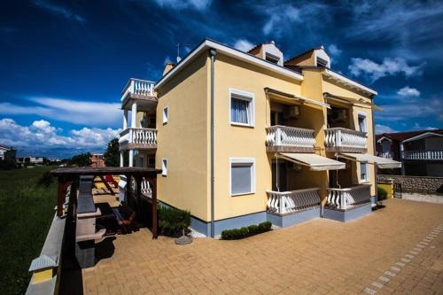 a large yellow building with a playground in front of it at Room in Zaton (Zadar) with Wi-Fi, washing machine (4141-8) in Zaton