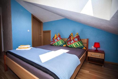 a bedroom with a large bed with blue walls at Room in Zaton (Zadar) with W-LAN, washing machine (4141-9) in Zaton