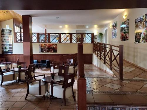 a restaurant with tables and chairs and a staircase at HOTEL MASIA EL MOLINETE in Mora de Rubielos