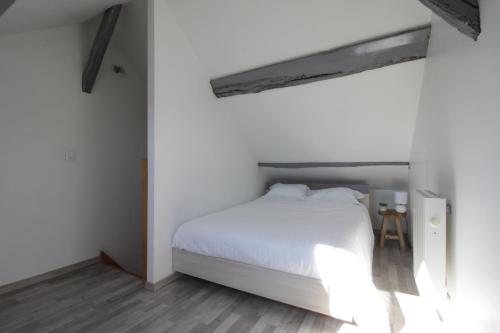 um quarto com uma cama branca e piso em madeira em L'Arpajonais 4 Cosy Hyper Centre 5min N20 em Arpajon