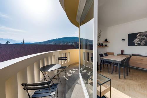 une chambre avec un balcon avec une table et des chaises dans l'établissement Le Panoramique - 75 sq m apartment with balcony in the heart of Annecy, à Annecy