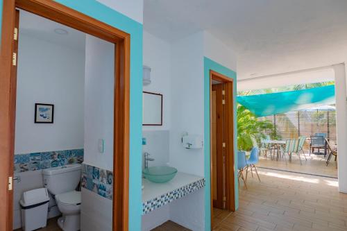 a bathroom with a toilet and a view of a patio at Casa Menta in Puerto Escondido