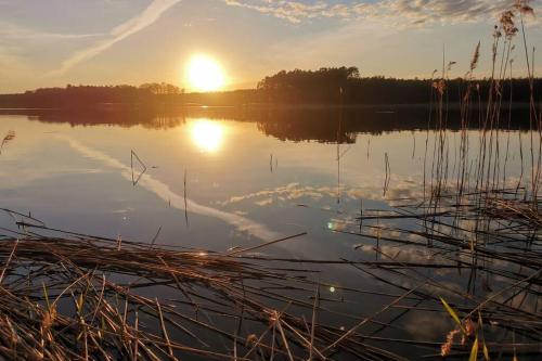 a view of a lake with the sun setting at Biała Dom z widokiem in Biala