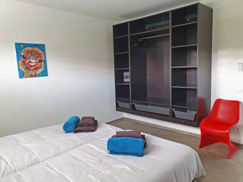 a bedroom with two beds and a red chair at Residence Selavi Curacao in Jan Thiel