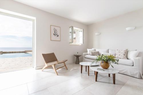 a white living room with a couch and a table at Amani Living in Stoupa