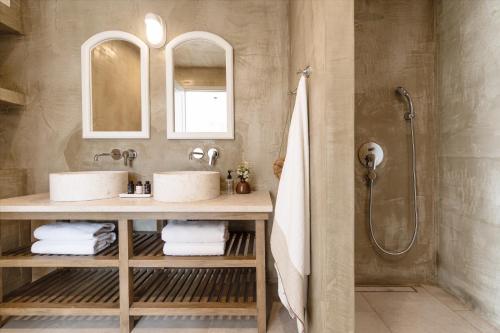 a bathroom with two sinks and a shower at Amani Living in Stoupa