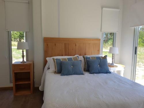 a bedroom with a large bed with blue pillows at Hacienda WF - Casa 1 in José Ignacio