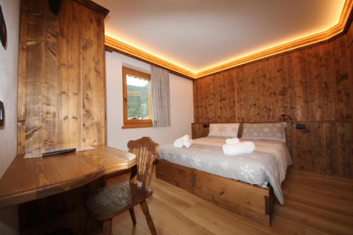 Schlafzimmer mit einem Bett, einem Schreibtisch und einem Schreibtisch in der Unterkunft Belvedere in Auronzo di Cadore