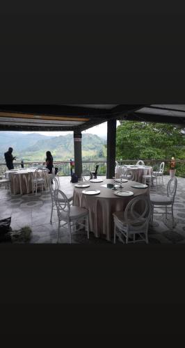 a group of tables and chairs with mountains in the background at Finca Campestre Villa del Campo in Santa Rosa de Cabal