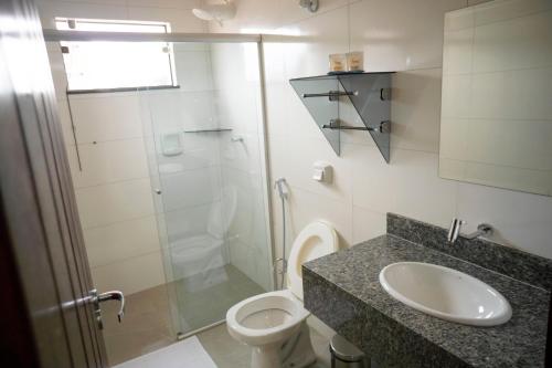 a bathroom with a toilet and a sink and a shower at Villa Vaz Hotel in Rondonópolis