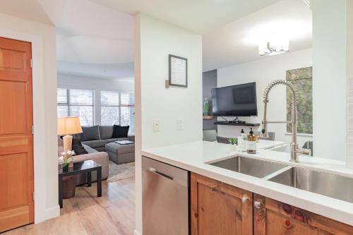 a kitchen with a sink and a living room at Northstar by Outpost Whistler in Whistler