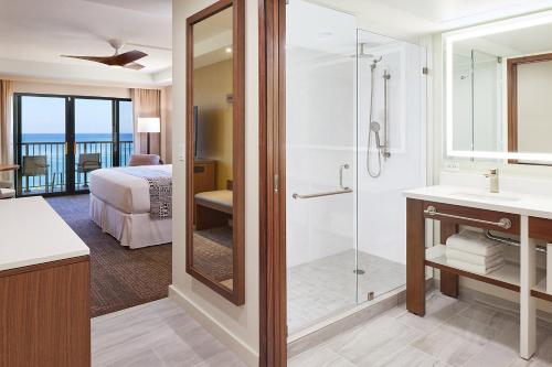 a hotel room with a bed and a shower at Ka'anapali Beach Hotel in Lahaina