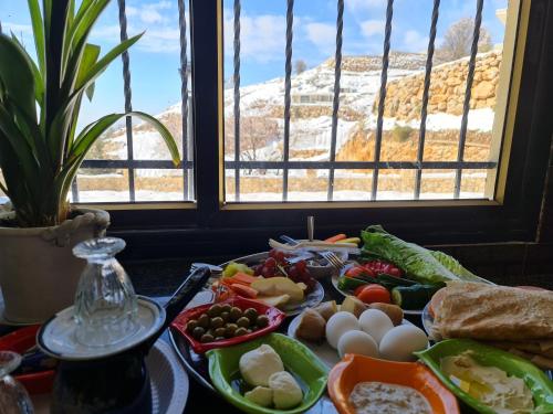 a table topped with plates of food next to a window at Vida Bhermon 2, one small wooden cabin in Majdal Shams