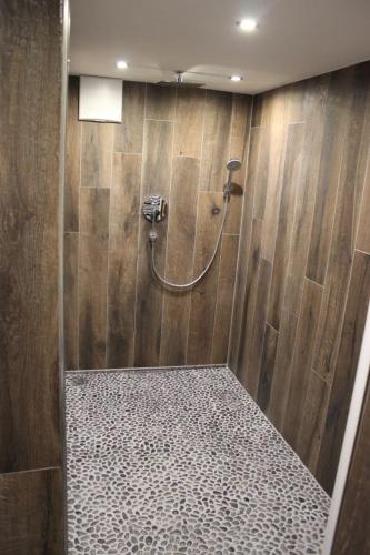 a bathroom with a shower with a wooden wall at Ferienwohnung Brustmann in Teisendorf
