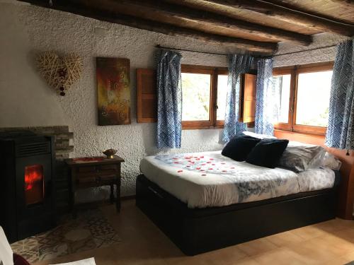 ein Schlafzimmer mit einem großen Bett und einem Kamin in der Unterkunft Cabaña en la naturaleza in Collado Villalba