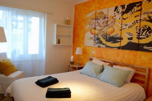 1 dormitorio con 1 cama y una gran pintura en la pared en Namasté - Ayurveda & Benessere, en Lugano