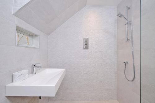 a white bathroom with a sink and a shower at Contemporary Highland House close to town and Ben Nevis in Fort William
