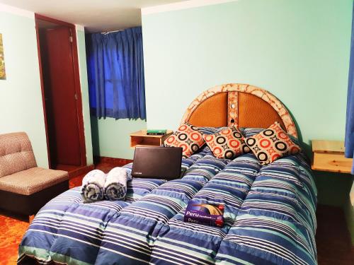 a bedroom with a bed with a laptop on it at Vacahouse Hostel - Huaraz in Huaraz