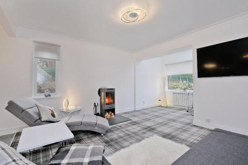 a living room with a fireplace and a tv at Contemporary Highland House close to town and Ben Nevis in Fort William