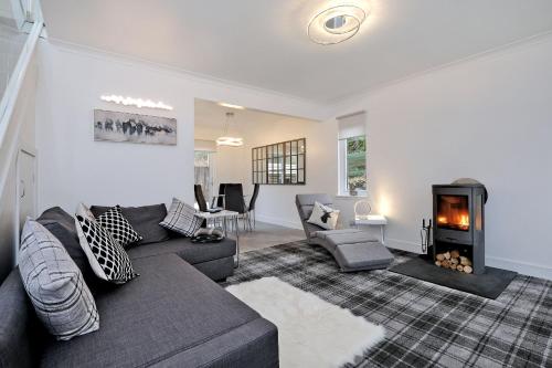a living room with a couch and a fireplace at Contemporary Highland House close to town and Ben Nevis in Fort William