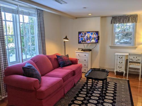 a living room with a purple couch and a tv at Stanton House Inn in Greenwich