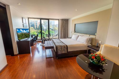 a hotel room with a bed and a balcony at Hotel Jazz Apartments in Bogotá