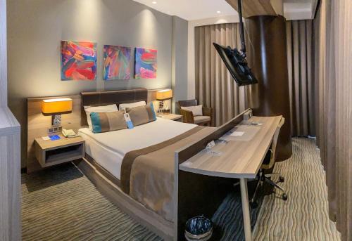 a hotel room with a bed and a desk at Ostimpark Business Hotel in Ankara