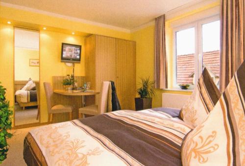 ein Schlafzimmer mit einem Bett und einem Tisch in einem Zimmer in der Unterkunft Gasthaus Zum güldenen Rößlein in Homburg