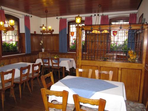 una sala da pranzo con tavoli, sedie e finestre di Gasthaus Zum güldenen Rößlein a Homburg