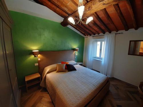a bedroom with a bed with a green wall at Il Vicolo in Lucca