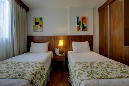 a hotel room with two beds and a window at Nobile Suites Monumental in Brasilia